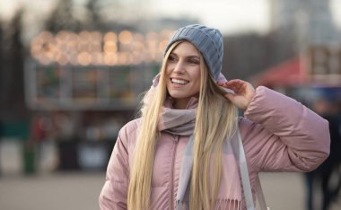 Güzel sarışın bir kadın arka planda bokeh ışıkları var.