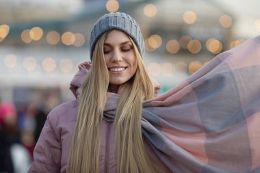Güzel sarışın bir kadın arka planda bokeh ışıkları var.