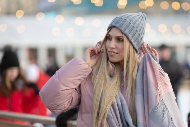 Güzel sarışın bir kadın arka planda bokeh ışıkları var.