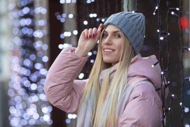 Güzel sarışın bir kadın arka planda bokeh ışıkları var.