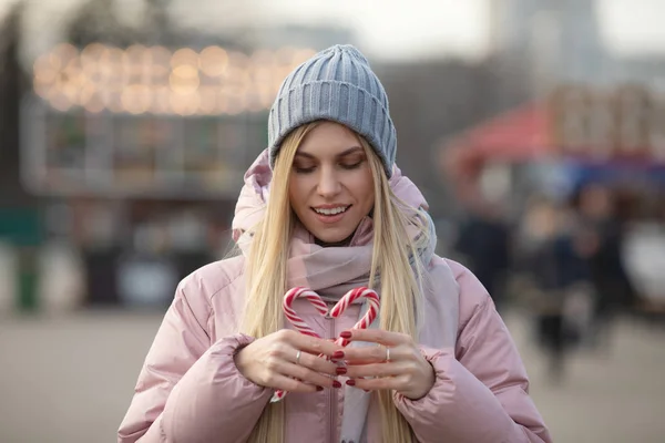 ヨーロッパの街の通りにポーズキャンディと若い美しい幸せな女性の肖像画 クリスマス — ストック写真