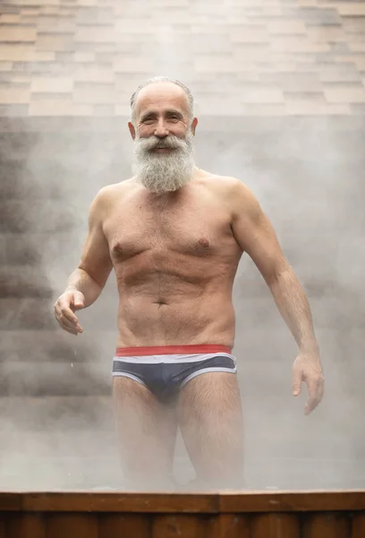 Bearded senior man enjoying thermal bath in thalassotherapy center.