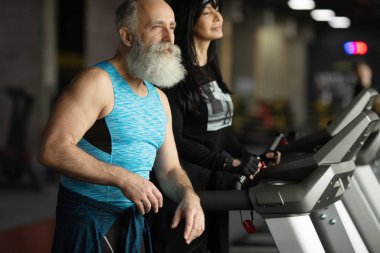 Güzel gülümseyen yaşlı çift spor salonunda egzersiz yapıyor..