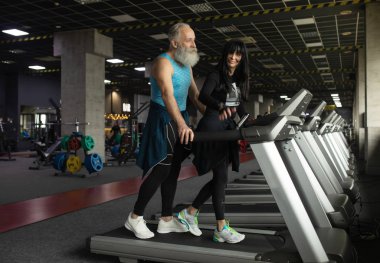 Güzel gülümseyen yaşlı çift spor salonunda egzersiz yapıyor..