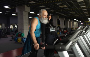 Güzel gülümseyen yaşlı çift spor salonunda egzersiz yapıyor..