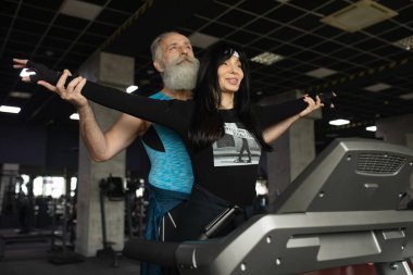 Güzel gülümseyen yaşlı çift spor salonunda egzersiz yapıyor..