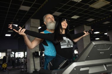 Güzel gülümseyen yaşlı çift spor salonunda egzersiz yapıyor..