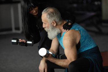 Güzel gülümseyen yaşlı çift spor salonunda egzersiz yapıyor..