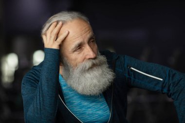 Spor salonundaki yaşlı sakallı adam. Egzersiz sonrası dinlenme