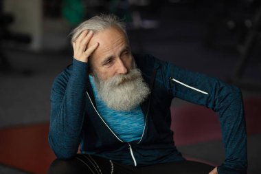 Spor salonundaki yaşlı sakallı adam. Egzersiz sonrası dinlenme