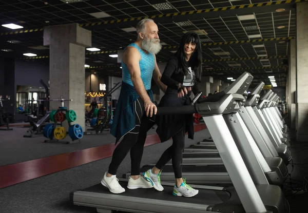 Güzel gülümseyen yaşlı çift spor salonunda egzersiz yapıyor..