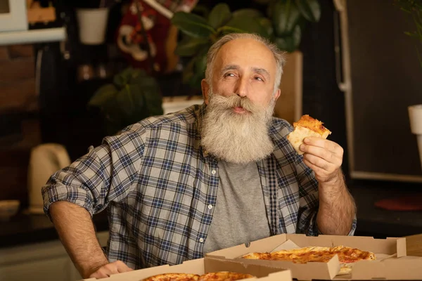 Een Glimlachende Oudere Man Die Pizza Eet Woonkamer Bebaarde Senior — Stockfoto