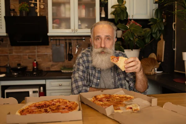 Een Glimlachende Oudere Man Die Pizza Eet Woonkamer Bebaarde Senior — Stockfoto