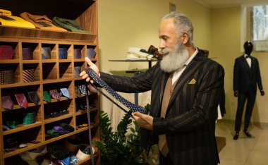 Şık ve modern kıdemli iş adamı pahalı mağazalarda kravat seçip alıyor..