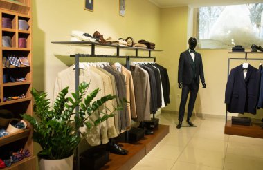 İş elbisesi dükkanının içinde. Pahalı takım elbiseler büyük miktarlarda askılarda asılı duruyor.
