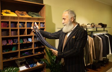 Şık ve modern kıdemli iş adamı pahalı mağazalarda kravat seçip alıyor..