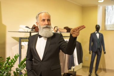 Ciddi sakallı son sınıf öğrencisinin portresi. Siyah takım elbiseli damat, kelebek kravatı, butik mağazasında kravat, dükkan..