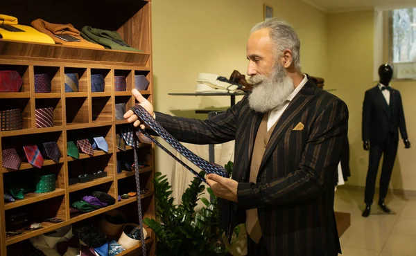 Şık ve modern kıdemli iş adamı pahalı mağazalarda kravat seçip alıyor..