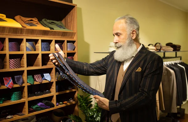 Şık ve modern kıdemli iş adamı pahalı mağazalarda kravat seçip alıyor..