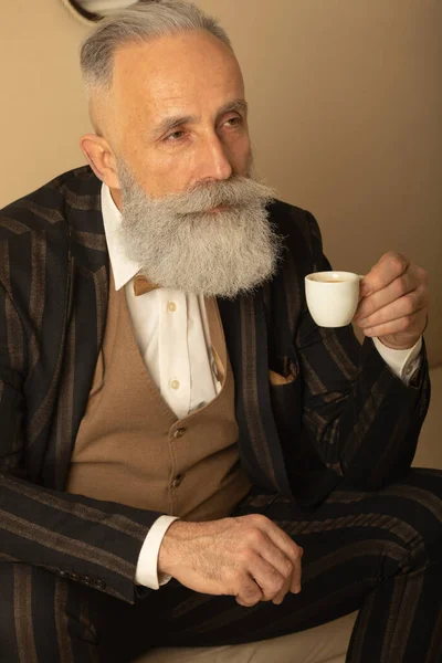 Starszy Przystojny Skoncentrowany Mężczyzna Broda Biznes Garnitur Siedzi Pije Kawę — Zdjęcie stockowe