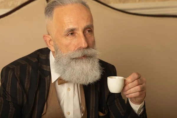 Uomo Anziano Bello Concentrato Con Barba Abito Lavoro Seduto Bere — Foto Stock