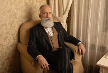 Lüks içinde iyi giyimli, sakallı kıdemli bir adam..