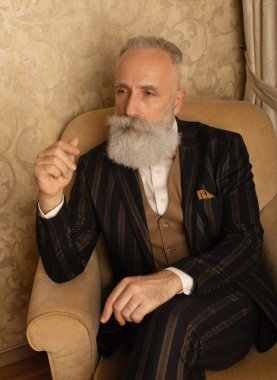 Lüks içinde iyi giyimli, sakallı kıdemli bir adam..