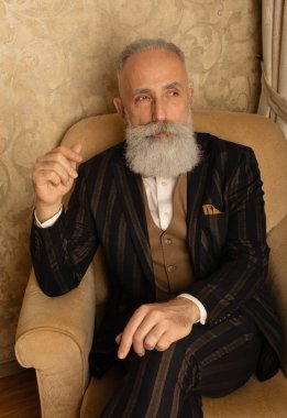 Lüks içinde iyi giyimli, sakallı kıdemli bir adam..