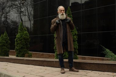 Gri saçlı ve sakallı son sınıf öğrencisi sokakta..
