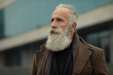Gri saçlı ve sakallı son sınıf öğrencisi sokakta..