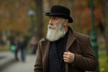 Gri saçlı ve sakallı son sınıf öğrencisi sokakta..