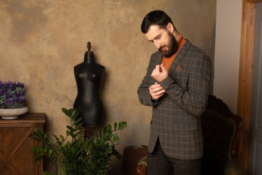 Klasik iç mimarisi olan bir odada saygıdeğer genç sakallı bir adam. Lüks. Erkek güzelliği, moda.