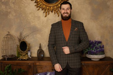 Klasik iç mimarisi olan bir odada saygıdeğer genç sakallı bir adam. Lüks. Erkek güzelliği, moda.