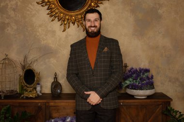 Klasik iç mimarisi olan bir odada saygıdeğer genç sakallı bir adam. Lüks. Erkek güzelliği, moda.
