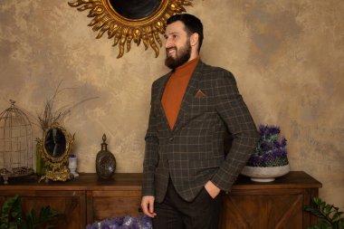 Klasik iç mimarisi olan bir odada saygıdeğer genç sakallı bir adam. Lüks. Erkek güzelliği, moda.