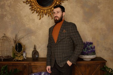 Klasik iç mimarisi olan bir odada saygıdeğer genç sakallı bir adam. Lüks. Erkek güzelliği, moda.