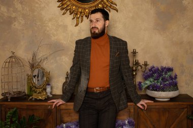 Klasik iç mimarisi olan bir odada saygıdeğer genç sakallı bir adam. Lüks. Erkek güzelliği, moda.