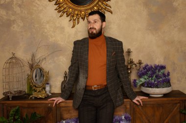 Klasik iç mimarisi olan bir odada saygıdeğer genç sakallı bir adam. Lüks. Erkek güzelliği, moda.