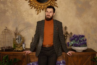 Klasik iç mimarisi olan bir odada saygıdeğer genç sakallı bir adam. Lüks. Erkek güzelliği, moda.