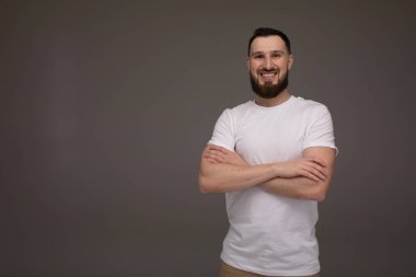 Şık yakışıklı sakallı işadamı gri izole kamera bakıyor.