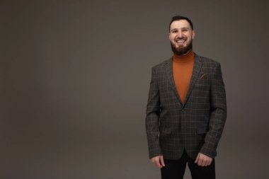 Yakışıklı iş adamı gri arka planda kameraya gülümsüyor..