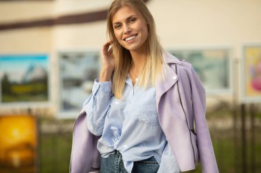 Çekici, genç, sarışın kadın portresi. Baharın güneşli arka planında bir kadın. Sonbaharda neşeli bir kadın portresi..