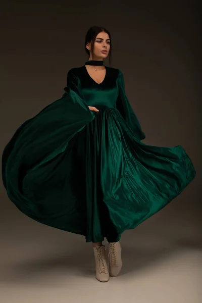 Woman in beauty fashion green gown, beautiful girl dancing in long evening dress.