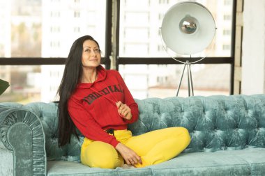 Güzel bir genç kadın evde kanepede rahatlatıcı.