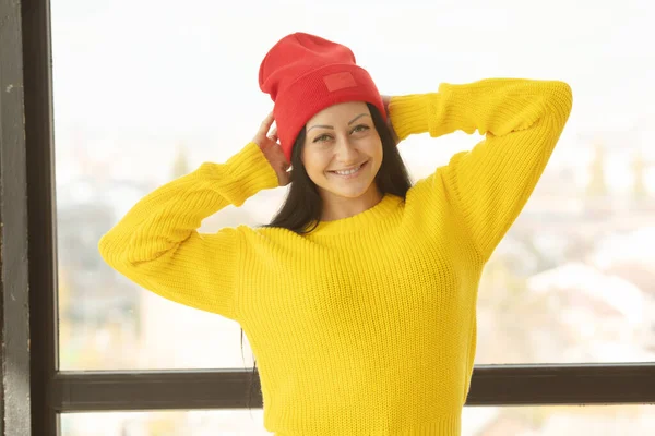 Woman indoor portrait. Young beautiful woman in warm  yellow knitted clothes at home.