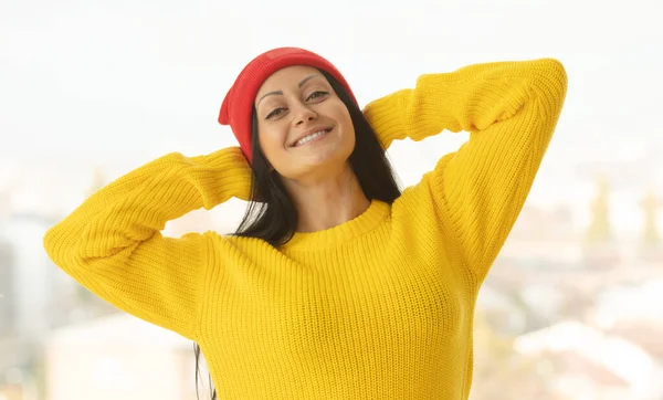 Woman indoor portrait. Young beautiful woman in warm  yellow knitted clothes at home.