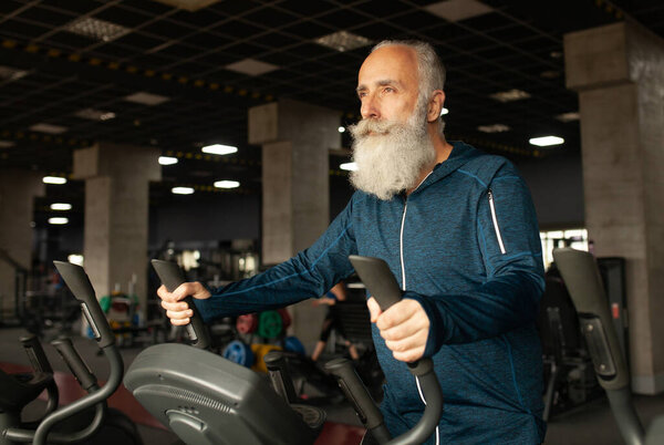 Senior Man On Running Machine In Gym