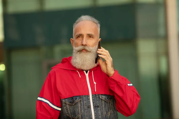 Snygg Seniorskäggig Man Pratar Med Smartphone Medan Han Tar Fikapaus — Stockfoto