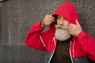 Şehirde yürüyen aktif kıdemli bir adam. Dışarıda dikilen sakallı yaşlı bir adamın portresi..