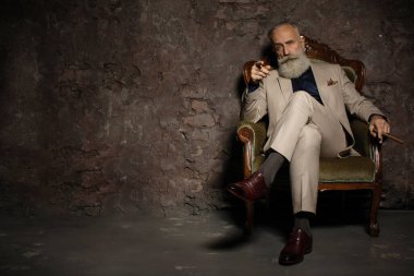 Yetişkin iş adamının son moda takım elbise giymiş portresi. Lüks içinde iyi giyimli, sakallı kıdemli bir adam..